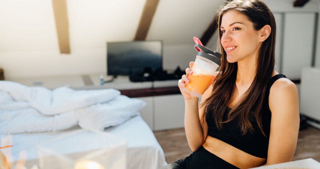 A happy woman drinking a sports drink